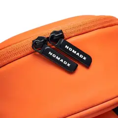Zipper pull and NomadX branding on the Sunset Orange bag